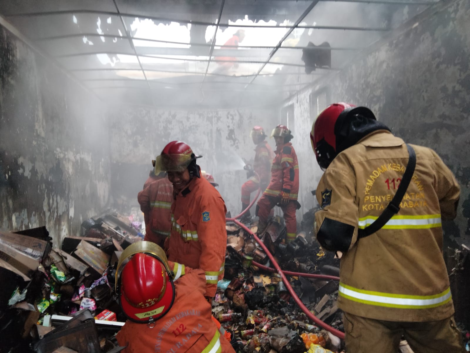 Petugas berusaha menjinakkan si jago merah yang melalap sebuah minimarket di Jalan Kalibutuh, Surabaya pada Senin (29/1/2024) sore. Foto: Command Center 112