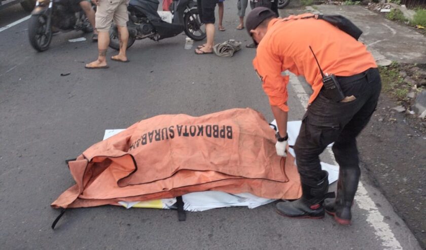 Petugas mengevakuasi jenazah pemotor asal Brebes yang meninggal dunia di Jalan Raya Mastrip Surabaya pada Selasa (30/1/2024) pagi. Foto: Command Center 112