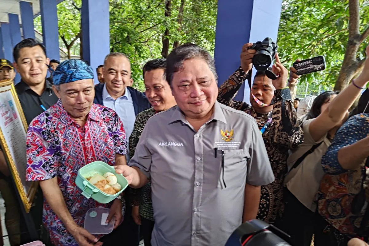 Airlangga Hartato Menteri Koordinator Bidang Perekonomian menunjukkan menu makan siang gratis untuk pelajar di SMPN 2 Curug, Kabupaten Tangerang, Banten. Foto: Antara