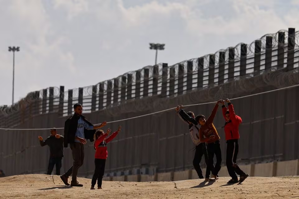 Anak-anak Palestina yang mengungsi karena serangan Israel, bermain saat mereka berlindung di perbatasan dengan Mesir, di tengah konflik Israel dan Hamas, di Rafah di Jalur Gaza selatan, pada Kamis (15/2/2024). Foro: Reuters