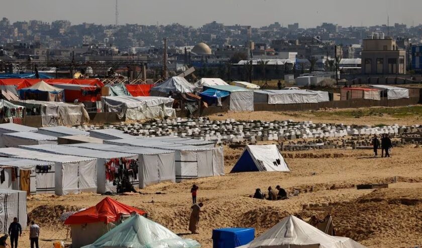 Warga Palestina yang mengungsi karena serangan Israel, berlindung di sebuah kamp tenda, di tengah konflik yang sedang berlangsung antara Israel dan kelompok Hamas, di perbatasan dengan Mesir, di Rafah, Jalur Gaza selatan, Kamis (8/2/2024). Foto: Reuters