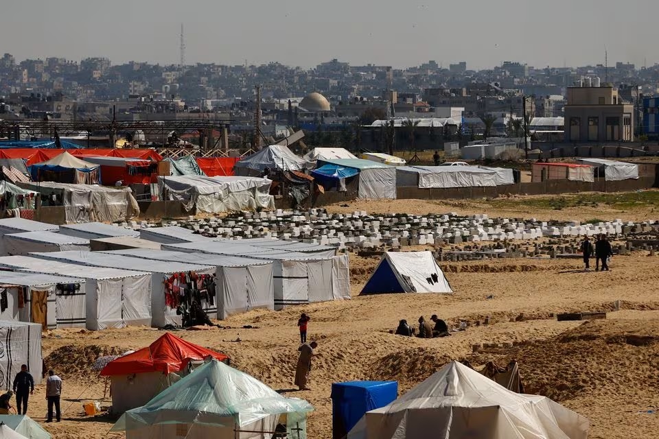 Warga Palestina yang mengungsi karena serangan Israel, berlindung di sebuah kamp tenda, di tengah konflik yang sedang berlangsung antara Israel dan kelompok Hamas, di perbatasan dengan Mesir, di Rafah, Jalur Gaza selatan, Kamis (8/2/2024). Foto: Reuters