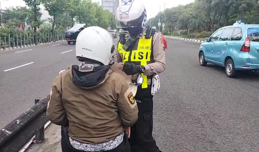 Polisi menilang pengendara sepeda motor yang tetap lewat Layang Mayangkara meski sudah ada rambu larangan pada Jumat (2/2/2024). Foto: Agung Andri Purnomo via WA SS