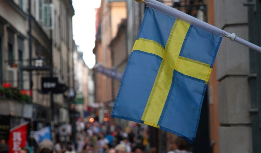 Ilustrasi bendera Swedia yang dibentangkan di luar sebuah toko di Stockholm pada 14 Juli 2023. Foto: Reuters