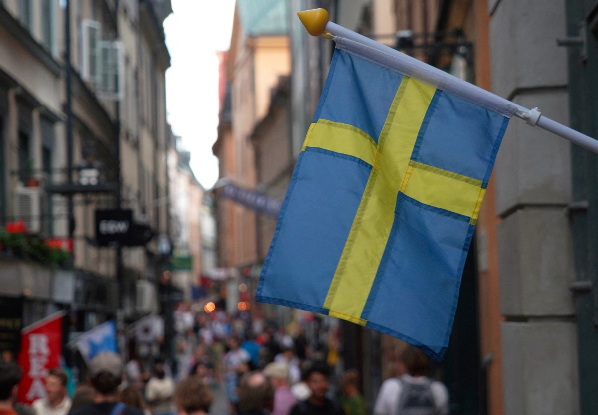 Ilustrasi bendera Swedia yang dibentangkan di luar sebuah toko di Stockholm pada 14 Juli 2023. Foto: Reuters