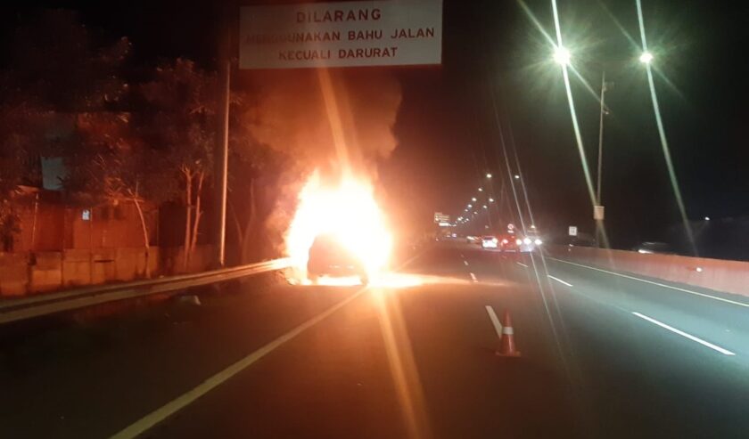 Mobil Land Cruise terbakar di KM 14A Tol Gunungsari arah Waru pada Minggu (4/2/2024) subuh. Foto: Senkom Jasa Marga