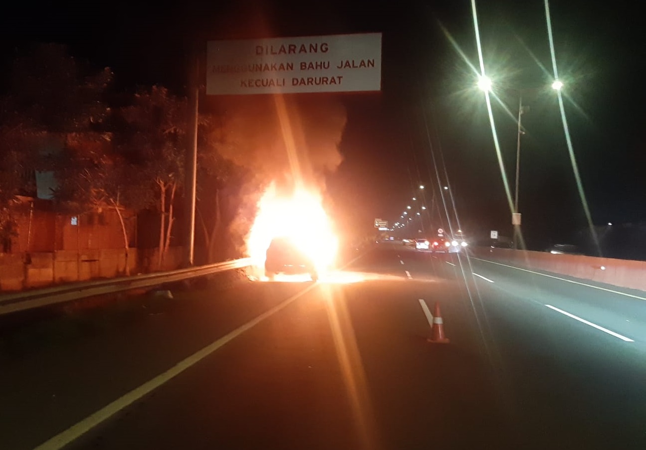 Mobil Land Cruise terbakar di KM 14A Tol Gunungsari arah Waru pada Minggu (4/2/2024) subuh. Foto: Senkom Jasa Marga