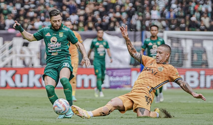 Robson Duerte pemain Persebaya Surabaya berebut bola dengan Radja Nainggolan penggawa Bhayangkara FC di Stadion Gelora Bung Tomo (GBT), Minggu (4/2/2024) sore. Foto: Persebaya