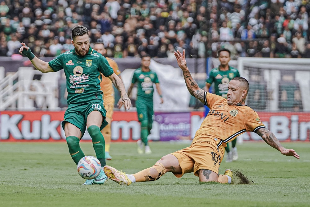 Robson Duerte pemain Persebaya Surabaya berebut bola dengan Radja Nainggolan penggawa Bhayangkara FC di Stadion Gelora Bung Tomo (GBT), Minggu (4/2/2024) sore. Foto: Persebaya