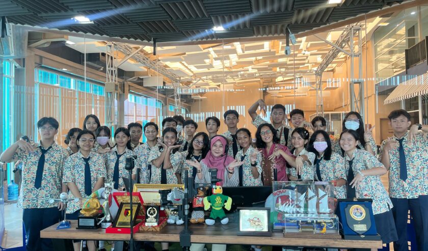 Aini Kusuma penyiar bersama siswa-siswi dan guru SMA Marge Surabaya berfoto bersama di ruang siaran Radio Suara Surabaya, Rabu (7/2/2024). Foto: Ikke magang suarasurabaya.net