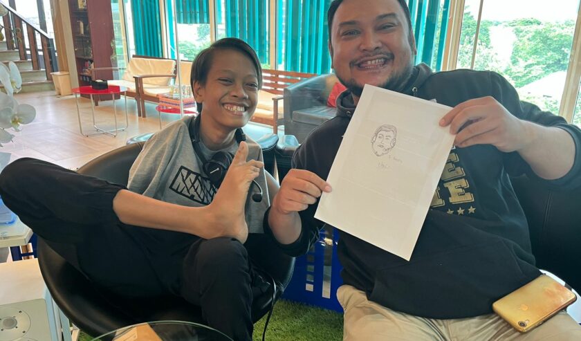 Ello Kusuma Alfred Mandeville dan Hendra Lukas Hutagalung penyiar Radio Suara Surabaya ketika menunjukkan hasil gambar wajah Hendra karya Ello. Foto: Billy suarasurabaya.net