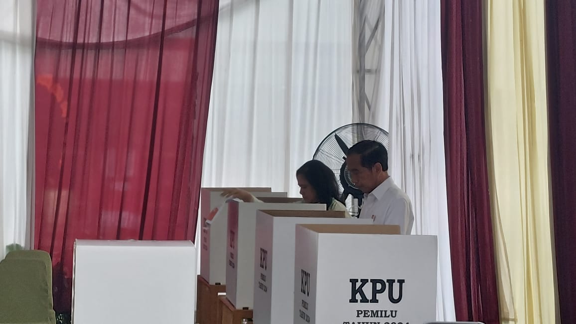 Jokowi Presiden dan Iriana Ibu Negara memasukkan surat suara ke kotak suara TPS 10, Gambir, Jakarta Pusat, Rabu (14/2/2024). Foto: Farid suarasurabaya.net