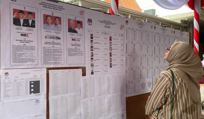 Pemilih saat melihat contoh surat suara di TPS 35 Karah Jambangan Surabaya sebelum menyoblos, Rabu (14/2/2024). Foto: Meilita suarasurabaya.net