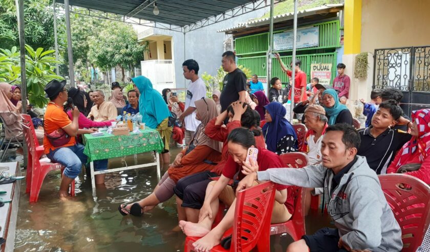Warga TPS 14 Desa Bringkang kecamatan Menganti saat menunggu antrian pencoblosan ditengah kondisi banjir, Rabu (14/2/2024). Foto: Ikke Magang suarasurabaya.net