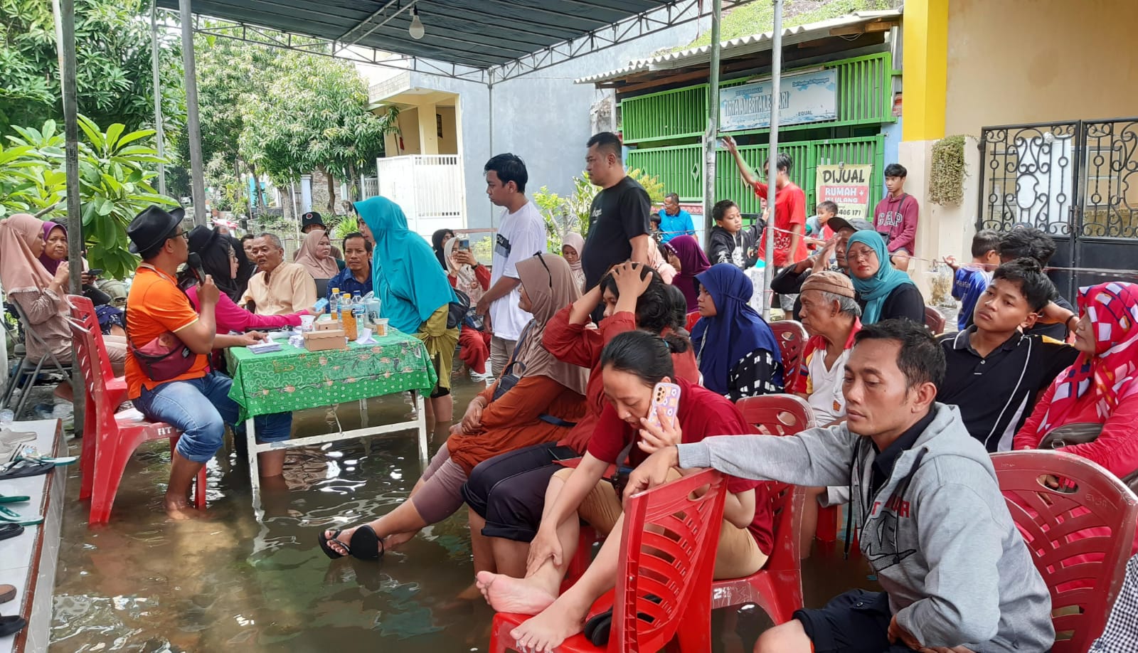 Warga TPS 14 Desa Bringkang kecamatan Menganti saat menunggu antrian pencoblosan ditengah kondisi banjir, Rabu (14/2/2024). Foto: Ikke Magang suarasurabaya.net