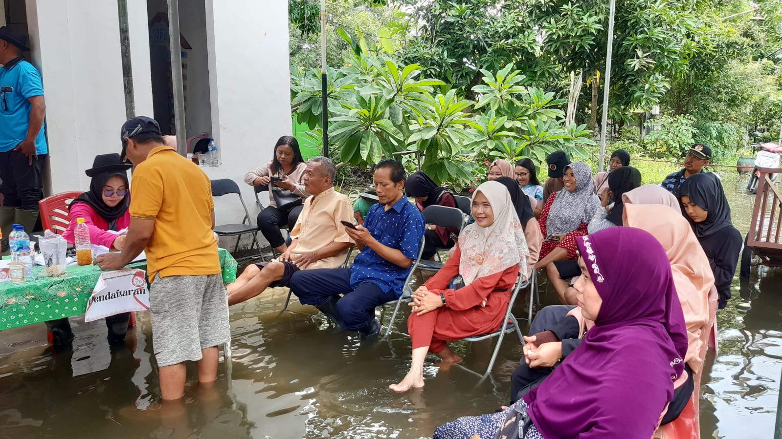 Warga TPS 14 Desa Bringkang kecamatan Menganti saat menunggu antrian pencoblosan setelah melakukan pendaftaran ditengah kondisi banjir, Rabu (14/2/2024). Foto: Ikke Magang suarasurabaya.net