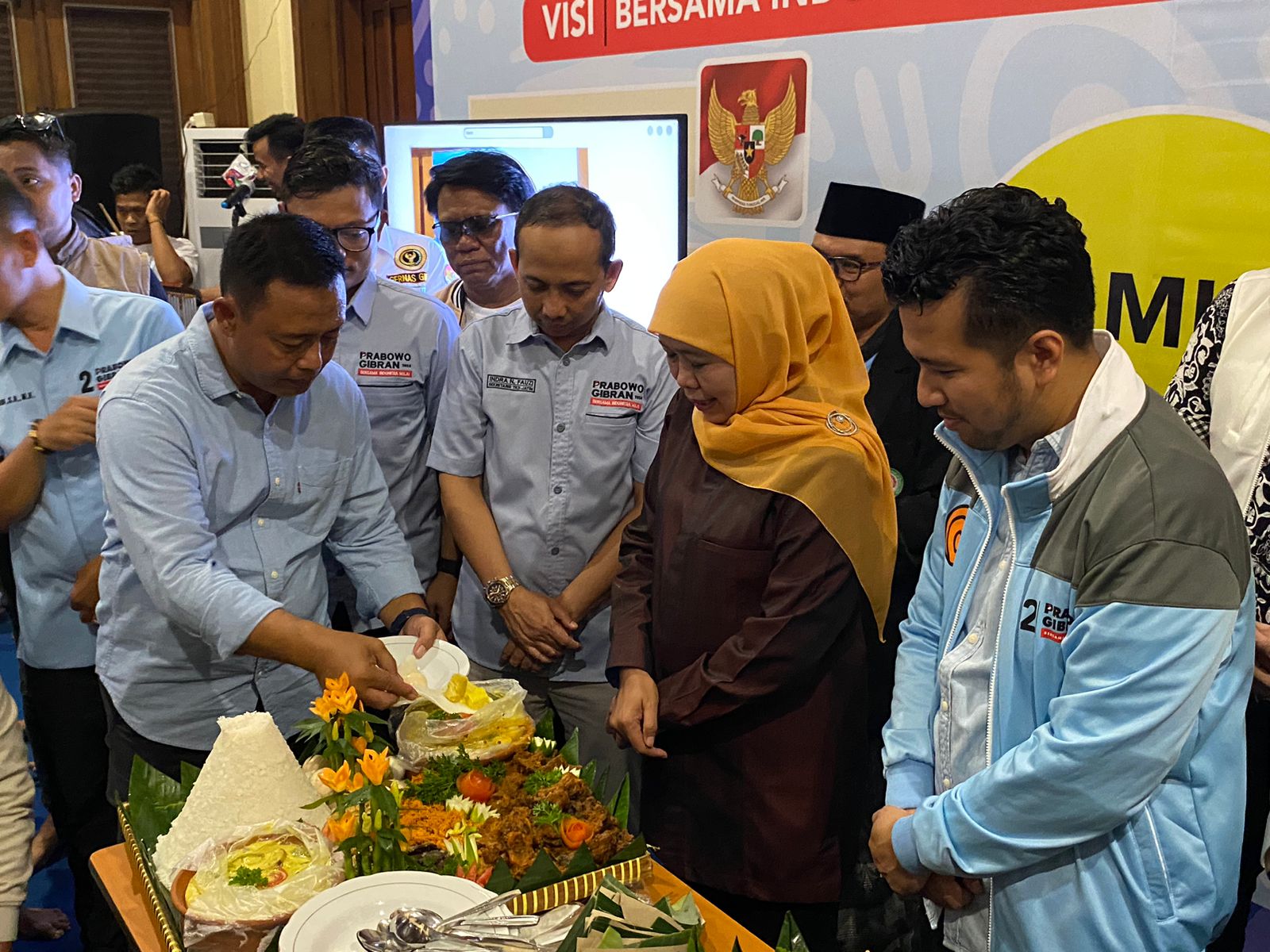 Boedi Prijo Soeprajitno Ketua TKD Prabowo-Gibran Jatim memotong tumpeng dan diberikan ke Khofifah Dewan Pengarah TKN Prabowo-Gibran, Rabu (14/2/2024). Foto: Wildan suarasurabaya.net