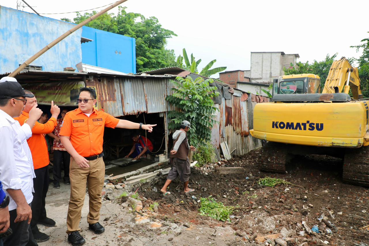 Adhy Karyono Plh Gubernur Jatim saat meninjau kesiapan alat berat di bantaran sungai untuk membersihkan eceng gondong di Sungai Buntung, Kamis (15/2/2024). Foto: Humas Pemprov Jatim.