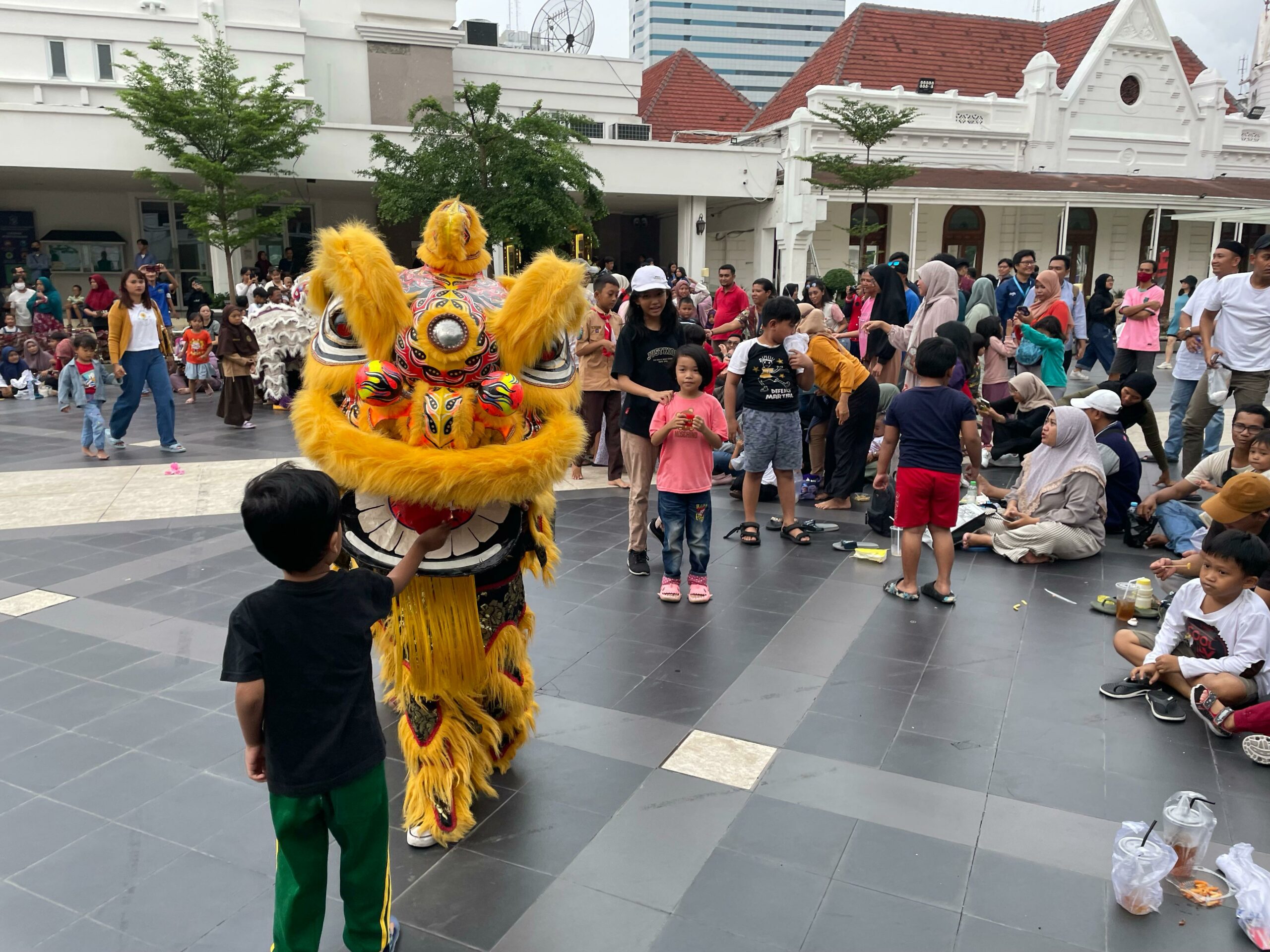 Momen anak kecil memberikan angpau pada Barongsai sesudah pertunjukan selesai di Alun-alun Kota Surabaya, Sabtu (17/2/2024). Foto: Firman Magang suarasurabaya.net