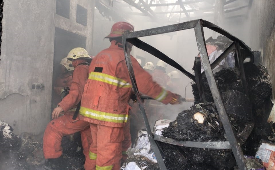 Petugas berusaha memadamkan api yang membakar sebuah rumah di Jalan Ampel Rahmat, Surabaya pada Sabtu (17/2/2024) sore. Foto: Command Center 112 Surabaya