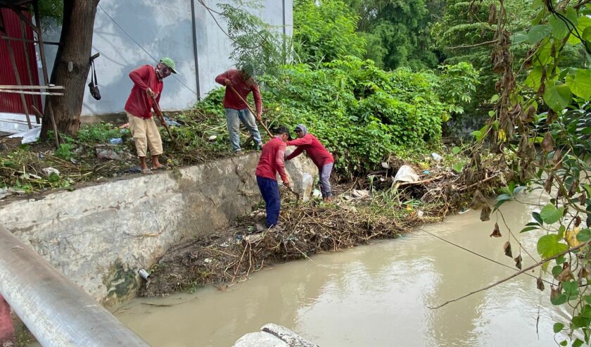 Petugas nampak membersihkan tumpukan ranting di sungai yang mengalir di dekat pemukiman Pakal Madya Barat, Minggu (18/2/2024). Foto: Wildan suarasurabaya.net