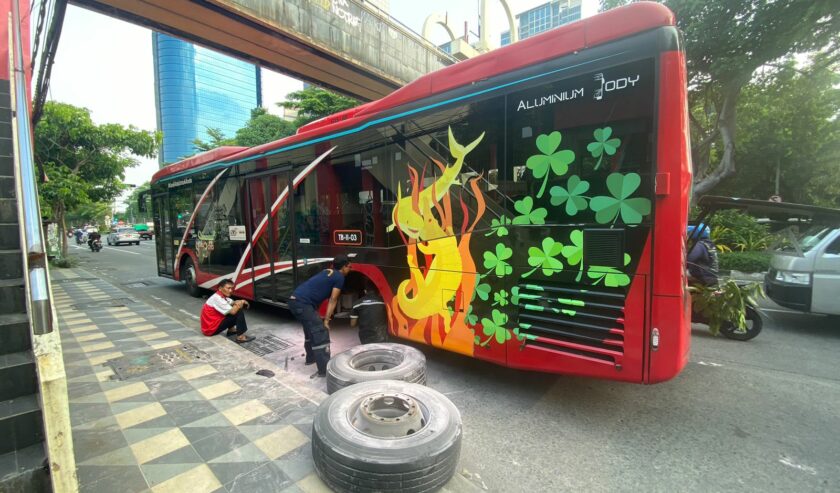 Kru service bus sedang memperbaiki bus Trans Semanggi yang berhenti di sisi kiri bahu Jalan Mayjend Sungkono, Selasa (20/2/2024). Foto: Wildan suarasurabaya.net