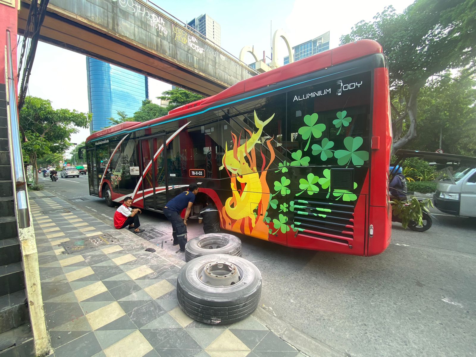 Kru service bus sedang memperbaiki bus Trans Semanggi yang berhenti di sisi kiri bahu Jalan Mayjend Sungkono, Selasa (20/2/2024). Foto: Wildan suarasurabaya.net