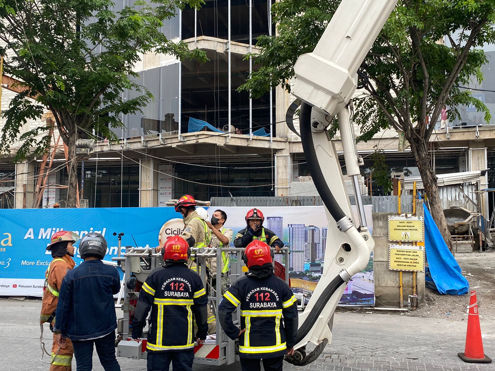 Petugas Damkar Kota Surabaya waktu melakukan persiapan melakukan pembasahan di lantai atas menggunakan bronto sky life di proyek pembangunan Apartemen Bella Tower Pakuwon City Surabaya, Rabu (21/2/2024). Foto: Wildan suarasurabaya.net