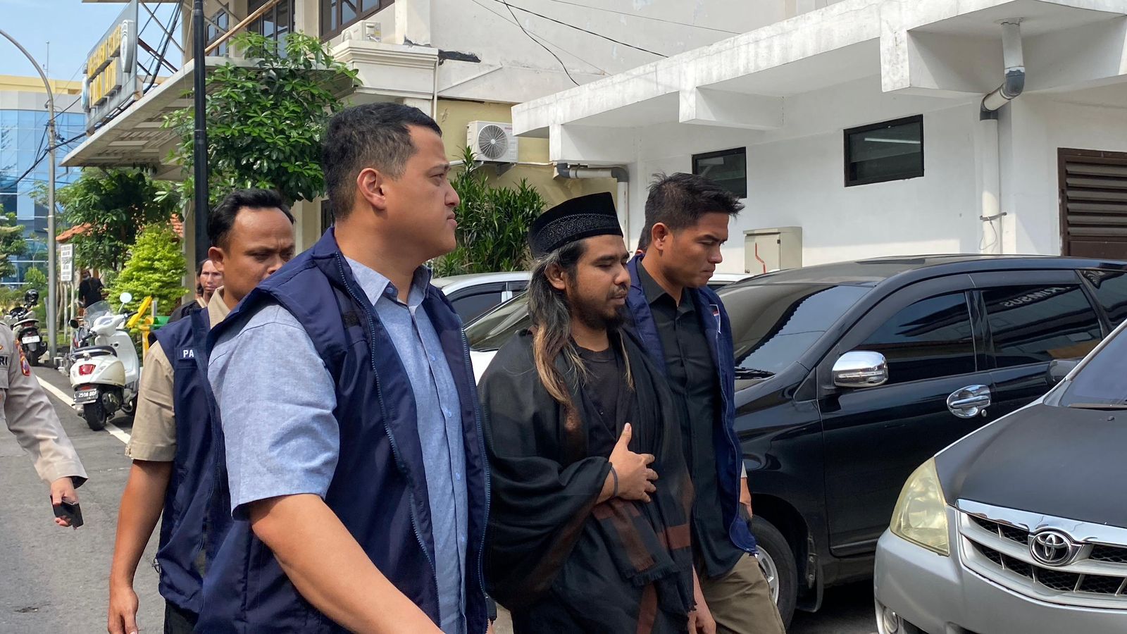 Gus Samsudin pengunggah video diduga aliran sesat di akun youtubenya saat keluar dari Gedung Ditreskrimsus Polda Jatim, Kamis (29/2/2024). Foto: Wildan suarasurabaya.net