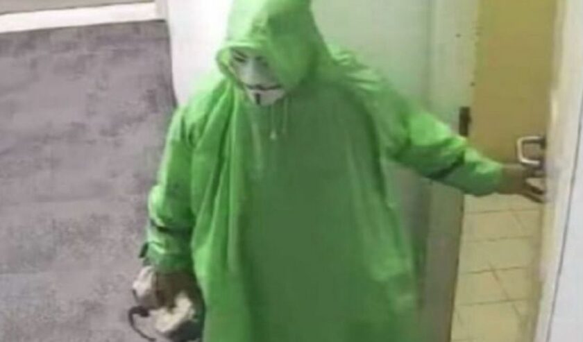 WH tersangka pencurian di kantor kawasan Kendangsari Surabaya sambil memakai topeng dan jas hujan warna hijau. Foto: Istimewa.