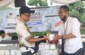 Septa Goemoelja Operator Pembayaran Mobil Keliling (Mobling) Bapenda saat memberikan souvenir kepada pengunjung yang sudah membayar PBB di Bank Jatim QRIS Ramadan Vaganza, di Balai Kota Surabaya, Rabu (27/3/2024). Foto: Istimewah