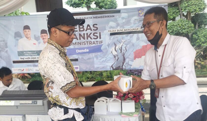 Septa Goemoelja Operator Pembayaran Mobil Keliling (Mobling) Bapenda saat memberikan souvenir kepada pengunjung yang sudah membayar PBB di Bank Jatim QRIS Ramadan Vaganza, di Balai Kota Surabaya, Rabu (27/3/2024). Foto: Istimewah