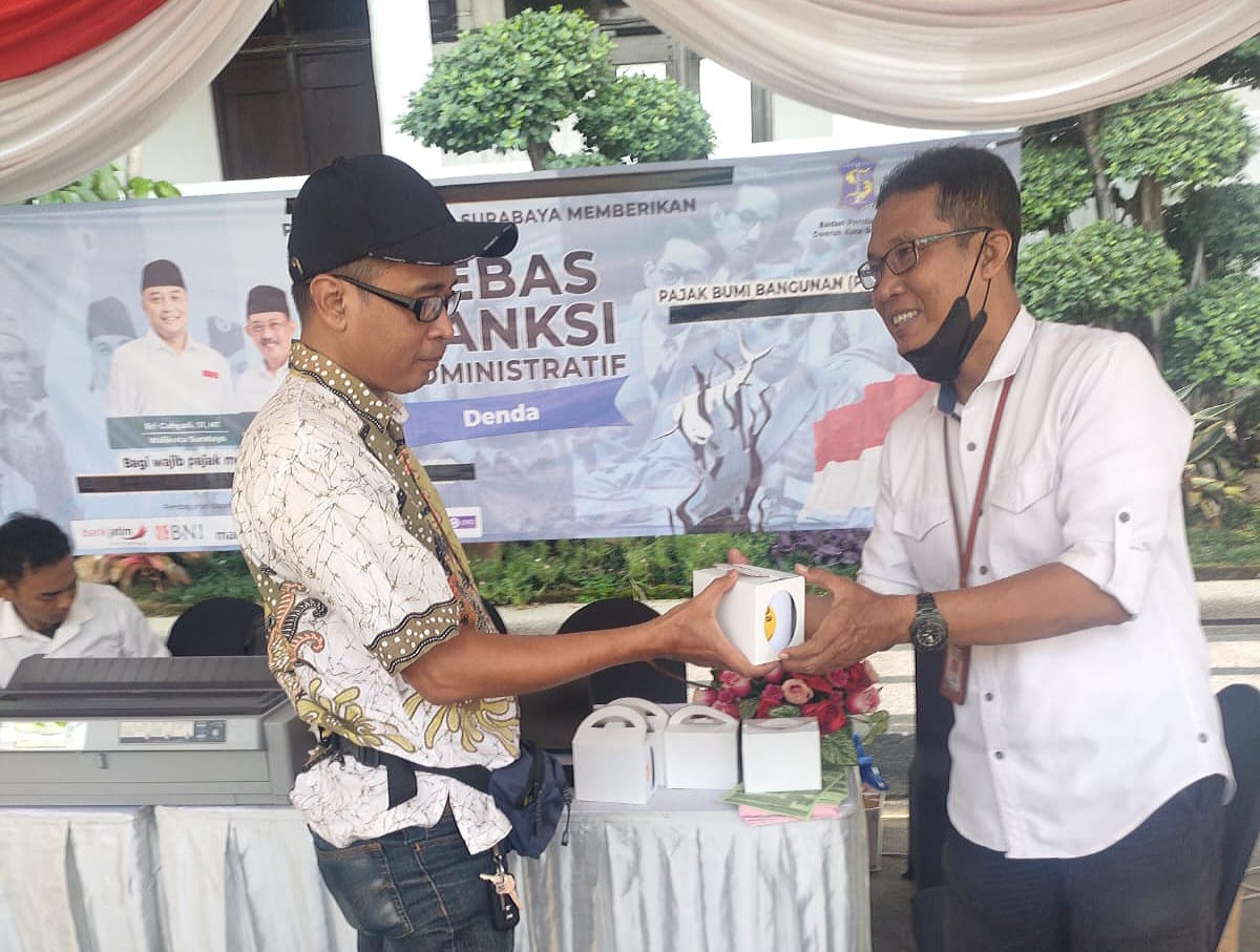 Septa Goemoelja Operator Pembayaran Mobil Keliling (Mobling) Bapenda saat memberikan souvenir kepada pengunjung yang sudah membayar PBB di Bank Jatim QRIS Ramadan Vaganza, di Balai Kota Surabaya, Rabu (27/3/2024). Foto: Istimewah