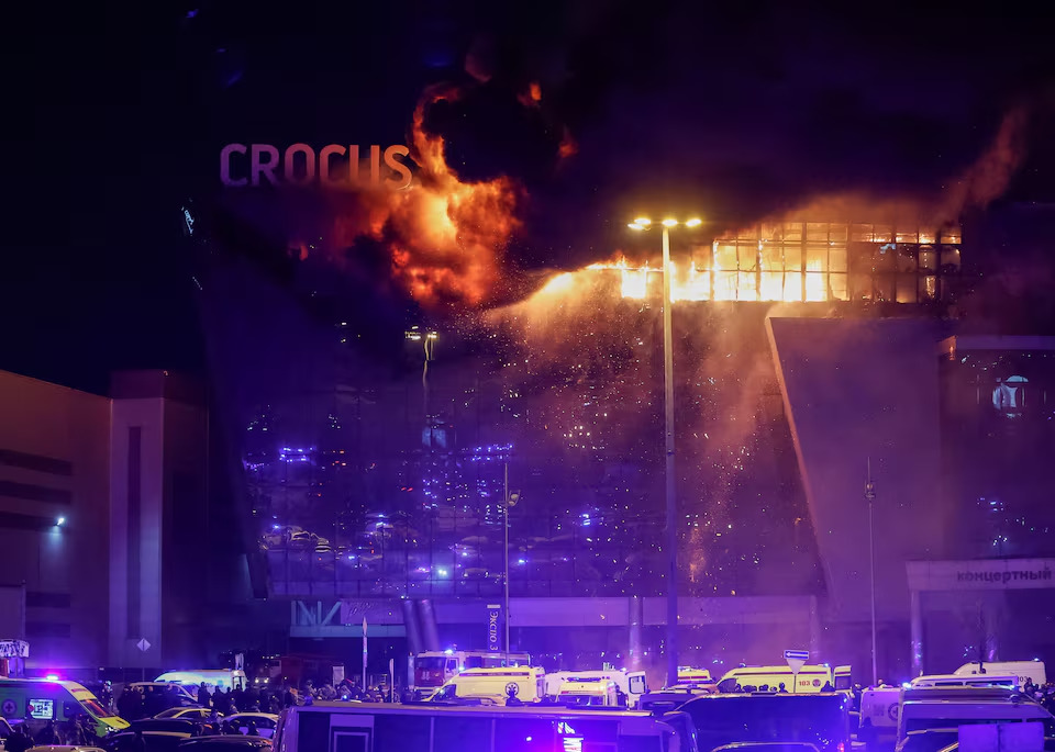 Ambulans dan kendaraan layanan darurat Rusia diparkir di luar lokasi konser Crocus City Hall yang terbakar menyusul insiden penembakan, di luar Moskow, Rusia, JUmat (22/3/2024). Foto: Reuters