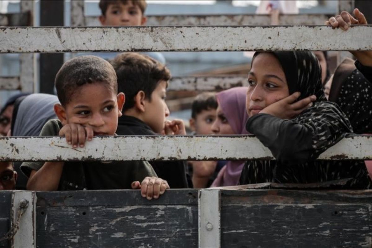 Anak-anak duduk di belakang truk saat warga Palestina berangkat dari bagian utara Gaza untuk meninggalkan Jalur Gaza bagian tengah dan selatan pada 10 November 2023. Foto: Anadolu