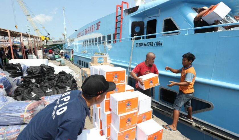 Sejumlah petugas mengangkut bantuan ke KM Bahari Express yang menuju ke Pulau Bawean, di Pelabuhan Gresik, Sabtu (23/3/2024). Foto: Antara