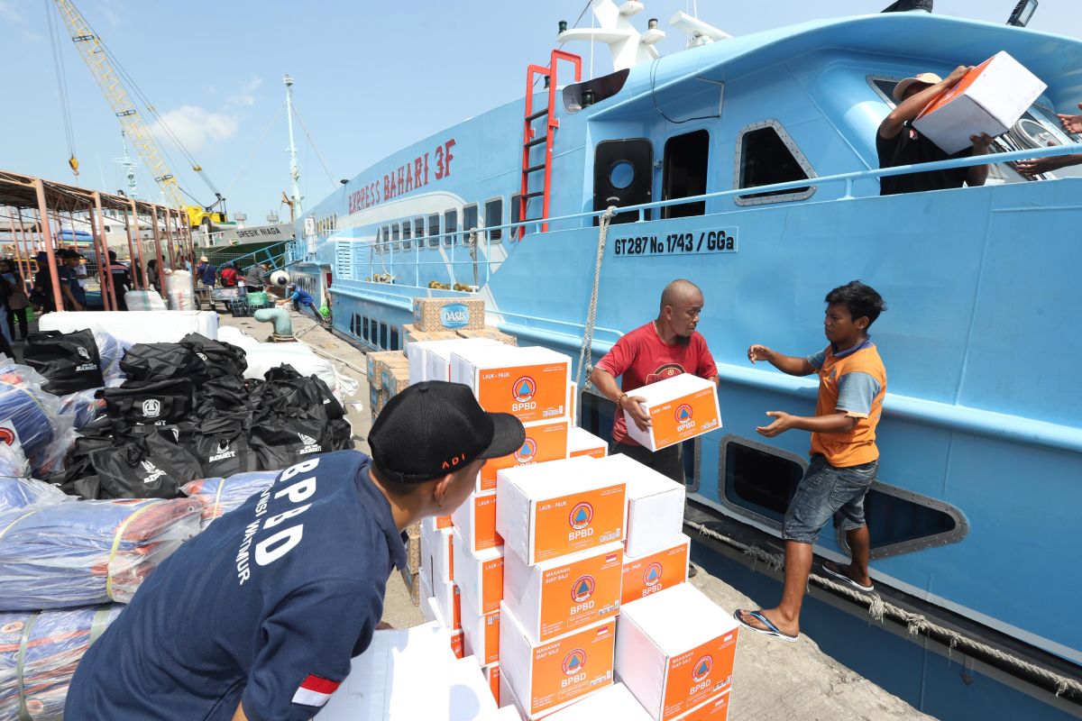 Sejumlah petugas mengangkut bantuan ke KM Bahari Express yang menuju ke Pulau Bawean, di Pelabuhan Gresik, Sabtu (23/3/2024). Foto: Antara