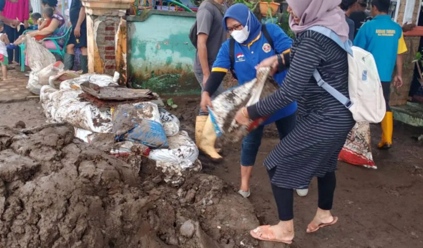 Karang Taruna Probolinggo lakukan kerja bakti membersihkan material lumpur di desa yang terdampak banjir di Kecamatan Dringu, Senin (11/3/2024). Foto: Diskominfo Probolinggo