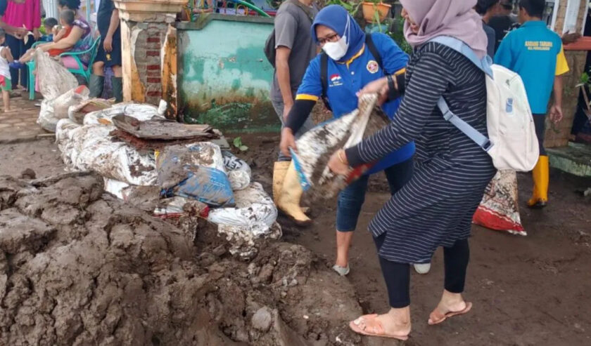 Karang Taruna Probolinggo lakukan kerja bakti membersihkan material lumpur di desa yang terdampak banjir di Kecamatan Dringu, Senin (11/3/2024). Foto: Diskominfo Probolinggo