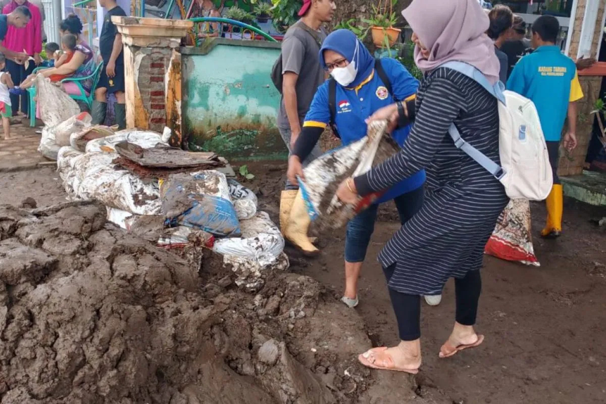 Karang Taruna Probolinggo lakukan kerja bakti membersihkan material lumpur di desa yang terdampak banjir di Kecamatan Dringu, Senin (11/3/2024). Foto: Diskominfo Probolinggo