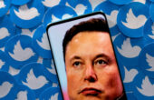 Ilustrasi gambar Elon Musk terlihat di smartphone yang ditempatkan pada cetakan logo Twitter. Foto: Reuters