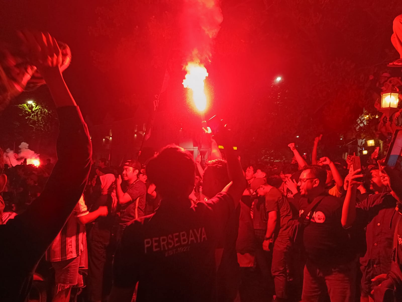 Bonek saat merayakan gol Persebaya dengan menyalakan flare di depan Polrestabes Surabaya, Rabu (27/3/2024). Foto: Risky suarasurabaya.net