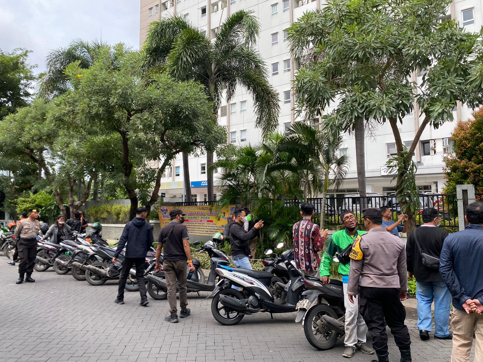 Puluhan driver ojol tiba di depan Apartemen Puncak Kertajaya Keputih Surabaya untuk unjuk rasa, Jumat (15/3/2024). Foto: Meilita suarasurabaya.net