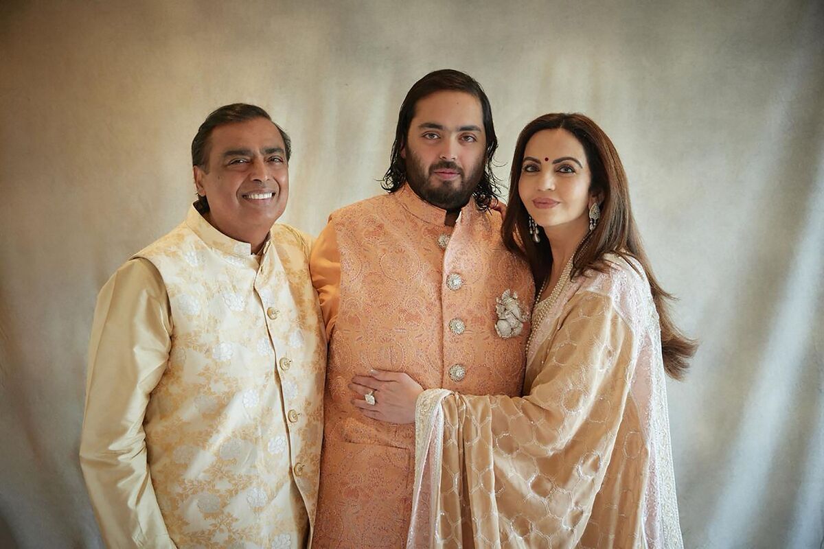 Mukesh Ambani (kiri) dan Nita Ambani (kanan), mengapit Anant Ambani putra mereka (tengah), pada sesi foto dalam rangkaian pesta prapernikahan Anant Ambani dan Radhika Merchant di Jamnagar, India, Sabtu (2/3/2024). Foto: Antara