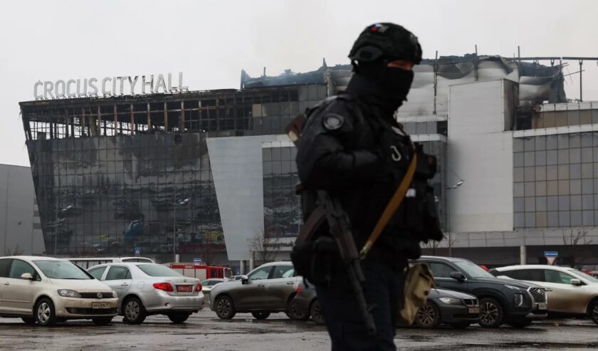 Seorang petugas penegak hukum berpatroli di lokasi serangan senjata pada Sabtu (23/3/2024). Foto: Getty Images