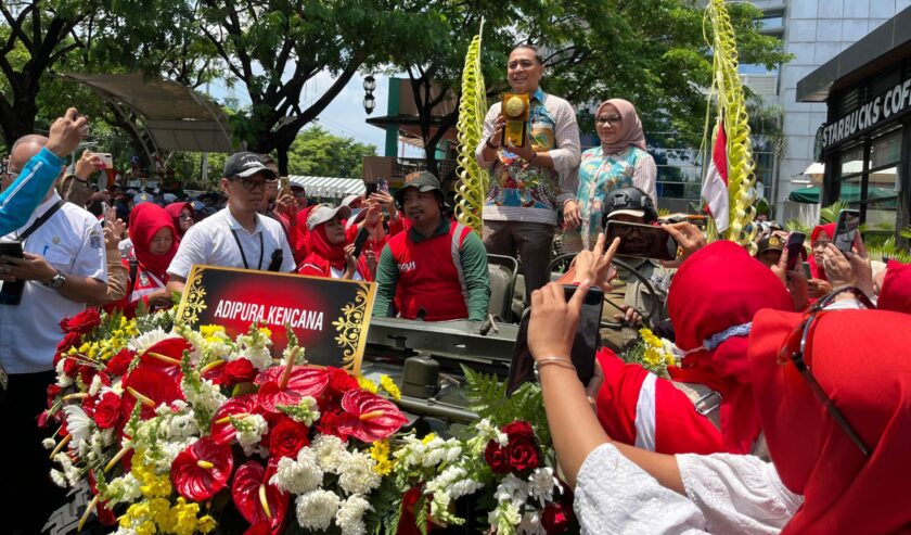 Eri Cahyadi Wali Kota Surabaya membawa Piala Adipura Kencana dari lokasi start DBL Arena Jl. A. Yani menuju Balai Kota Surabaya, Rabu (6/3/2024). Foto: Fitrah magang suarasurabaya.net