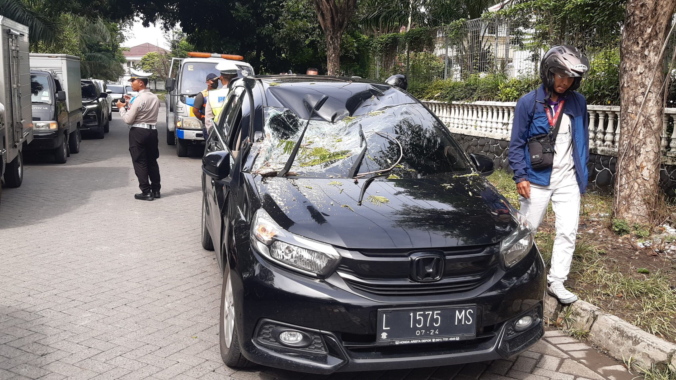 Kondisi mobil tertimpa pohon tumbang di kawasan Jalan Darmo Harapan Surabaya, usai dievakuasi petugas, Sabtu (9/3/2024). Foto: Ikke Magang suarasurabaya.net