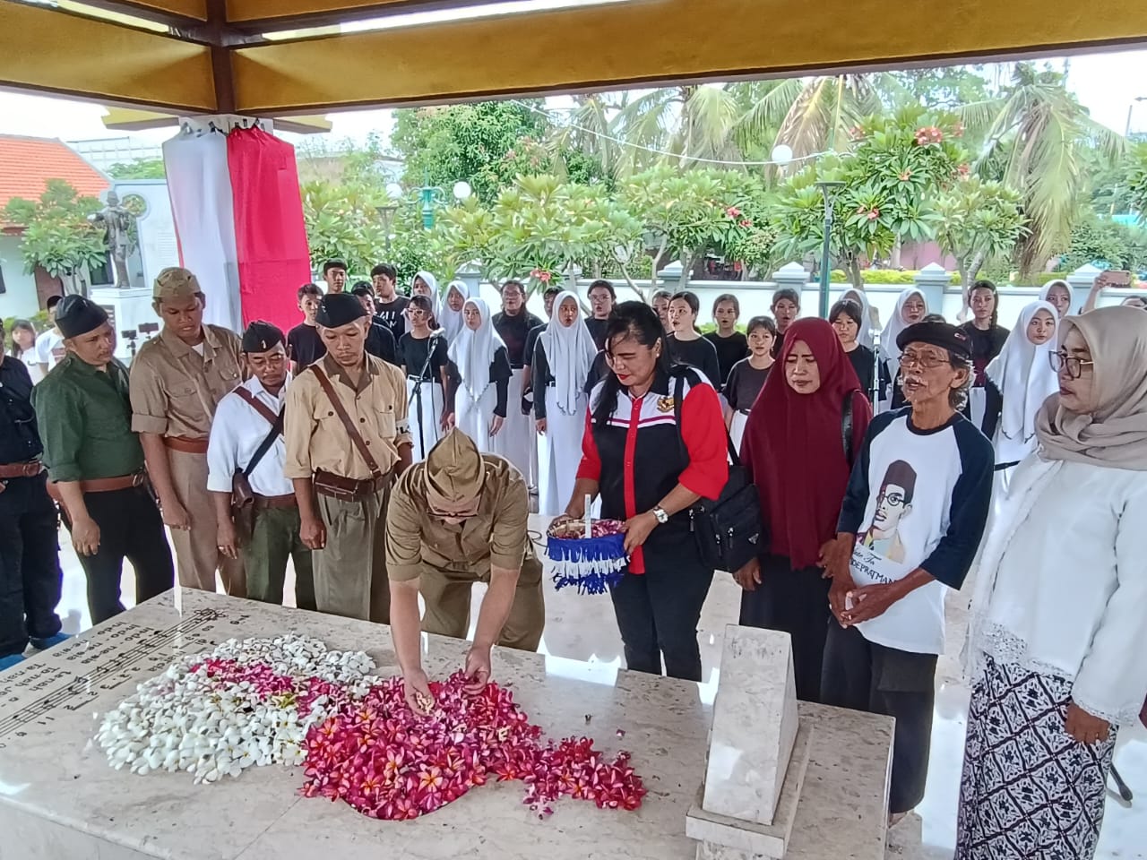 Para pegiat seni di Surabaya saat menaburkan bunga di atas makam WR. Soepratman, Surabaya, Sabtu (9/3/2024). Foto: Risky suarasurabaya.net