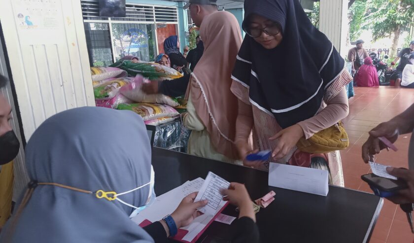 Warga membayar bahan pokok di Pasar Murah Kelurahan Pakis, Kecamatan Sawahan, Kota Surabaya, Selasa (12/3/2024). Foto: Dani magang suarasurabaya.net
