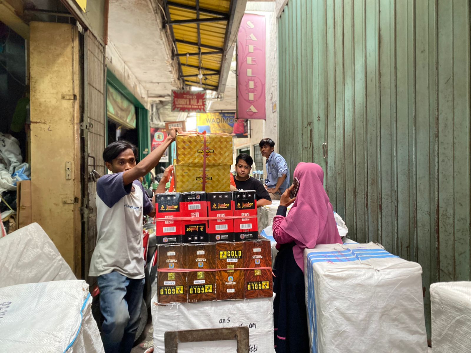 Aktivitas pemindahan barang dagangan alat salat di gang Pasar Bong Surabaya, Selasa (12/3/2024). Foto: Meilita suarasurabaya.net